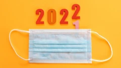 Foto de uma máscara com os numerais 2022 ao fundo