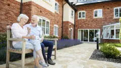 Retired Couple Sitting On Bench