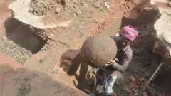 মাটির কলসি বের করে আনা হচ্ছে