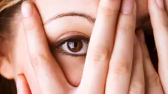 Woman looking through her fingers