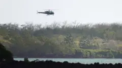 Search and rescue helicopter flies over the site of the collision off Mauritius on 31 August 2020