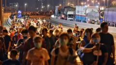 People queue to enter Singapore from Malaysia before a travel ban started