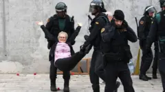 Una mujer cargada por la policía