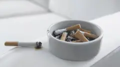 Cigarro e cinzeirocimaum sofá