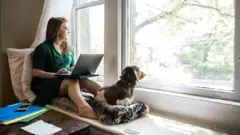 Mulher trabalhando de casa com cachorro