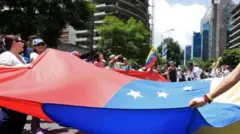 متظاهرون يرفعون علم فنزويلا
