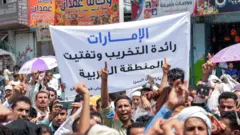 Demonstrators march with a sign reading in Arabic "the UAE is the leader of destruction and fragmenting the Arab region" during a protest in the southwestern city of Taez on August 30, 2019