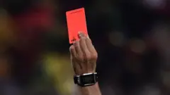 A referee showing a red card