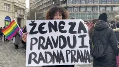 Žena drži transparent