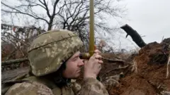 Membros do serviço ucraniano vigiam a área perto da linha de separação na região de Donetsk