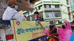 টিসিবির ভ্রাম্যমাণ ট্রাম থেকে পণ্য কিনছেন মানুষ।