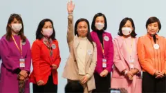 Candidates from the Election Committee constituency wave onstage after winning