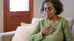 Femme qui se tient la poitrine