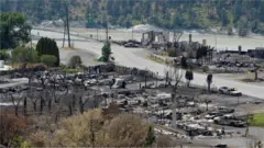 The charred remnants of homes and buildings, destroyed by a wildfire on June 30, are seen during a media tour by authorities in Lytton, British Columbia, Canada July 9, 2021.