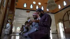 People praying at a mosque in Pakistan, defying government limits on the number of people gathering