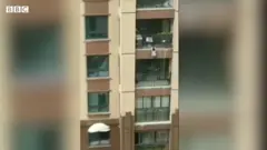 Garoto pendurado de prédio