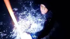 Mulher segura corda para sair do mar