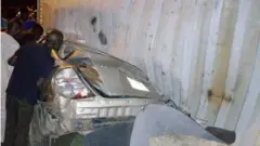 Kọntena kan wo lu ọkọ ayọkẹlẹ