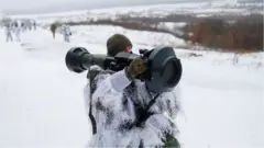 A Ukrainian service member holds a next generation light anti-tank weapon, supplied by the UK, during drills at Ukraine's International Peacekeeping Security Centre near Yavoriv.