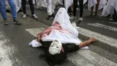 Una mujer recrea a un activista muerto en una manifestación en Colombia