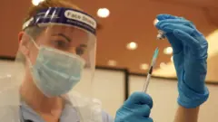 A woman preparing a vaccine at the Centre for Life in Newcastle