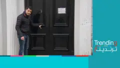 أحمد فاخوري يقف أمام باب أسود في أحد شوارع لندن