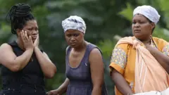 Women looking on at the flood damage.