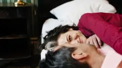 Mulher deitada ao lado de homem