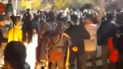 حشد من الناس يحتفلون بخسارة المنتخب الوطني الإيراني لكرة القدم بالرقص على أنغام الموسيقى في مدينة سانانداج شمال غربي البلاد