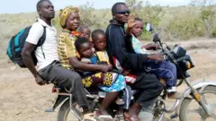 A boda boda operator transports a family of six on his bike in Kwale County, Kenya.