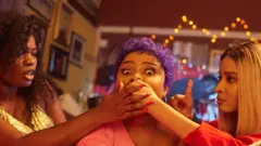 Scene from di movie wey two actresses dey cover anoda one mouth