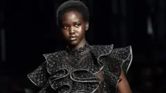 Le mannequin Adut Akech présente une création lors du défilé de mode de la collection Alberta Ferretti automne/hiver 2019/2020, le 20 février 2019 à Milan.