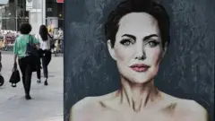"Aimez-vous", une peinture murale d'Alexsandro Palombo dans laquelle il dépeint Angelina Jolie montrant les signes d'une mastectomie lors de la Journée mondiale du cancer du sein. Piazza San Babila, Milan, mai 2023.