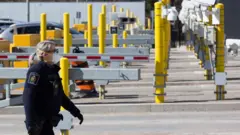 A Canadian border officer wears as face mask at the US/Canada border in Lansdowne, Ontario, on March 22, 2020.