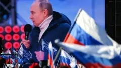 Tổng thống Nga Vladimir Putin xuất hiện trên màn hình khi ông có bài phát biểu trong buổi hòa nhạc đánh dấu kỷ niệm tám năm ngày Nga sáp nhập Crimea ngày 18 tháng 3 năm 2022