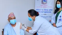 खोप लगाउँदै प्रधानमन्त्री