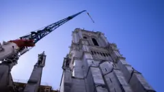 A crane looms over Notre-Dame cathedral in Paris