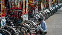 লকডাউনের সময় বাংলাদেশে একজন রিকসাচালক চাকা মেরামত করছে, ১৭-০৪-২০২০।