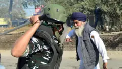 ਅਰਧ ਸੈਨਿਕ ਬਲ ਦੇ ਇੱਕ ਜਵਾਨ ਵੱਲੋਂ ਇੱਕ ਬਜ਼ੁਰਗ ਕਿਸਾਨ ਉੱਤੇ ਚੁੱਕਿਆ ਡੰਡਾ