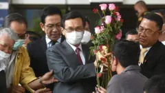 นายจาตุรนต์ ฉายแสง รับดอกไม้ให้กำลังใจจากผู้สนับสนุน หลังเสร็จสิ้นการรับฟังคำพิพากษา