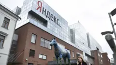 Женщина говорит по телефону возле главного офиса Яндекса в Москве, 16 мая 2017 года