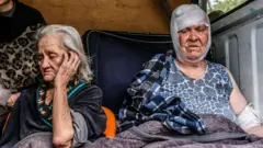 People from Severodonetsk are seen on a van that will take them to Kramatorsk on 25 May 2022