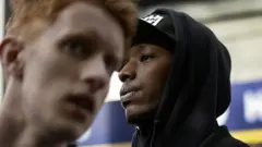 Un joven negro y un joven blanco en la estación de metro en el distrito de Husby, Estocolmo, donde hay una alta concentración de migrantes