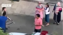 سرباز پلیس اسلحه را از ماشین بیرون می‌آورد و به سوی شهروندان می‌گیرد
