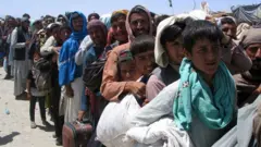 People wait to cross into Afghanistan, at the Friendship Gate crossing point at the Pakistan-Afghanistan border town of Chaman, Pakistan August 13, 2021