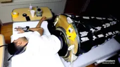 Una persona prueba un saco de dormir espacial
