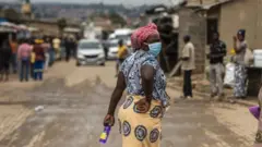 African woman dey wear mask