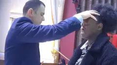 BBC reporter Katie Mark taking part in a UCKG service with Pastor Miguel Conte