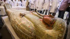 Employees of Egypt"s ministry of antiquities observe a sarchphagus displayed in front of Hatshepsut Temple in Egypt"s valley of the Kings in Luxor on October 19, 2019