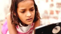 मोबाईल पाहणारी मुलगी